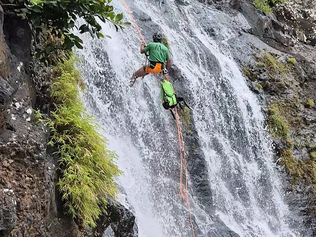 Una persona fa canyoning lungo una cascata impetuosa a Tamarind Falls